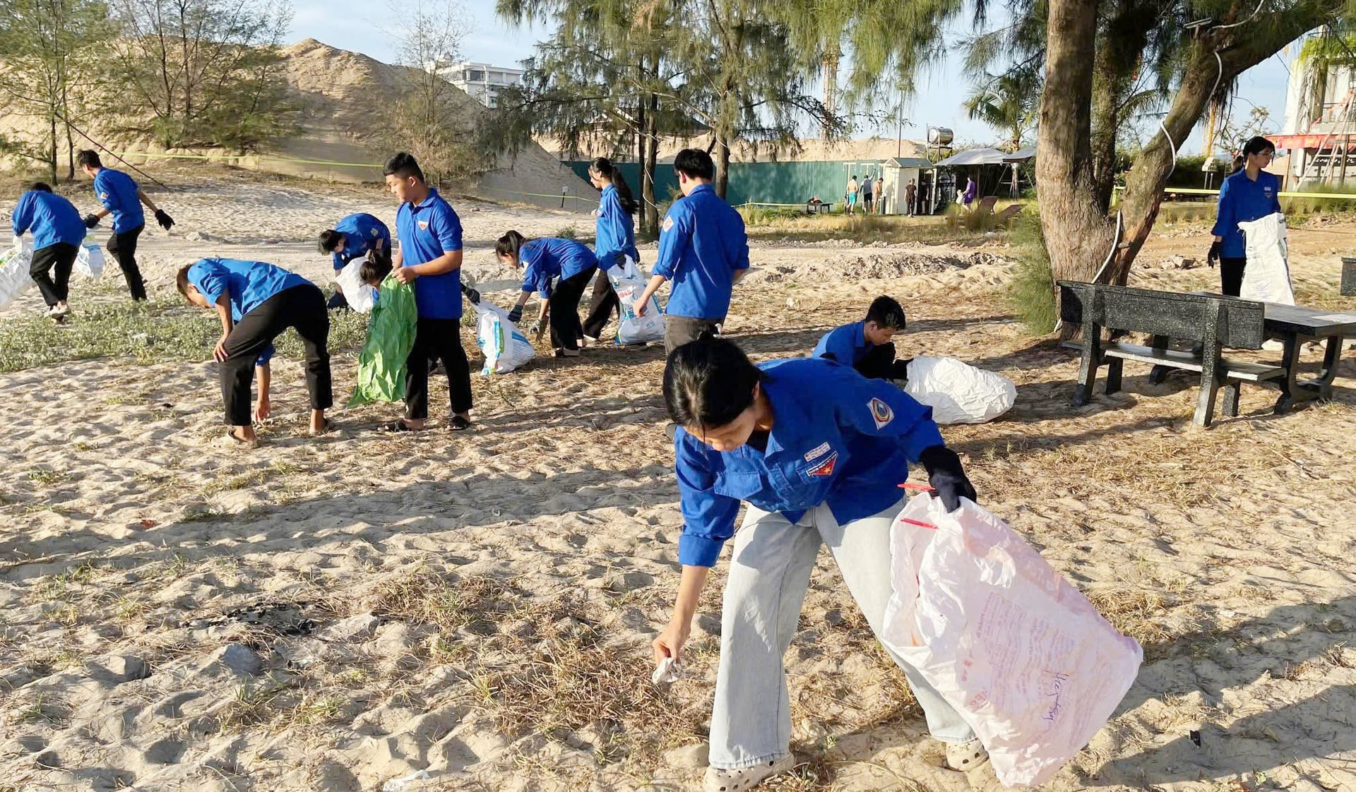 Lực lượng tình nguyện thu gom rác thải trên bãi biển Nhật Lệ. Ảnh: T. Nhi.