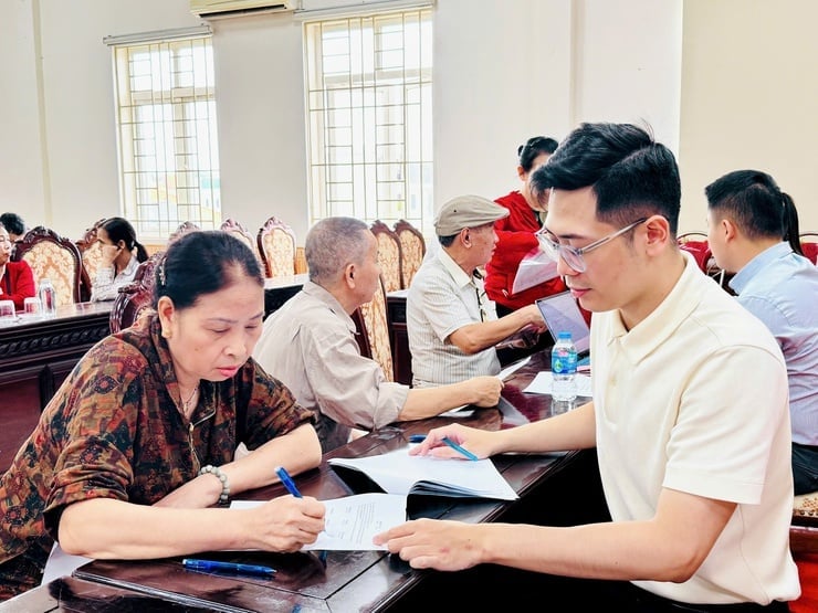 Cán bộ xã Nam Phù thực hiện công tác chi trả tiền bồi thường giải phóng mặt bằng cho người dân. Ảnh: Phương Xuyến.