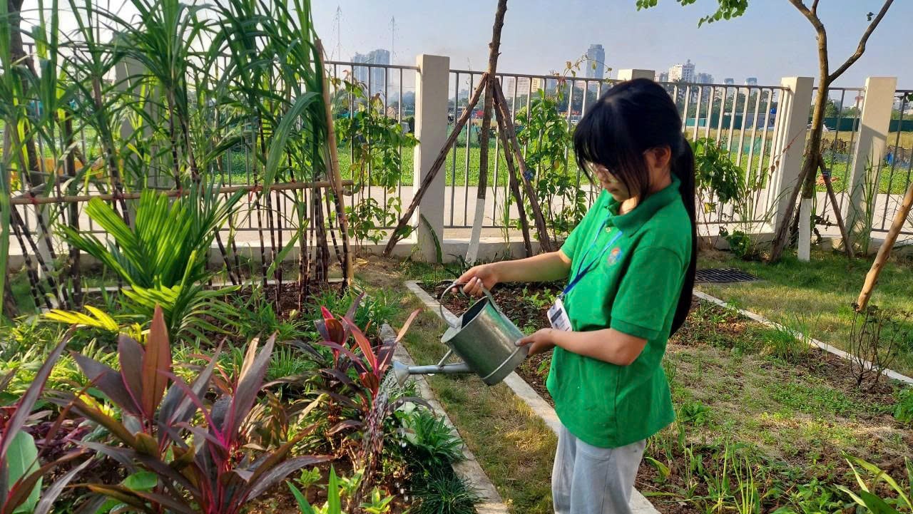 Học sinh tưới cây tại vườn sinh thái trong khuôn viên hệ thống giáo dục Genesis. Ảnh: Lan Chi.