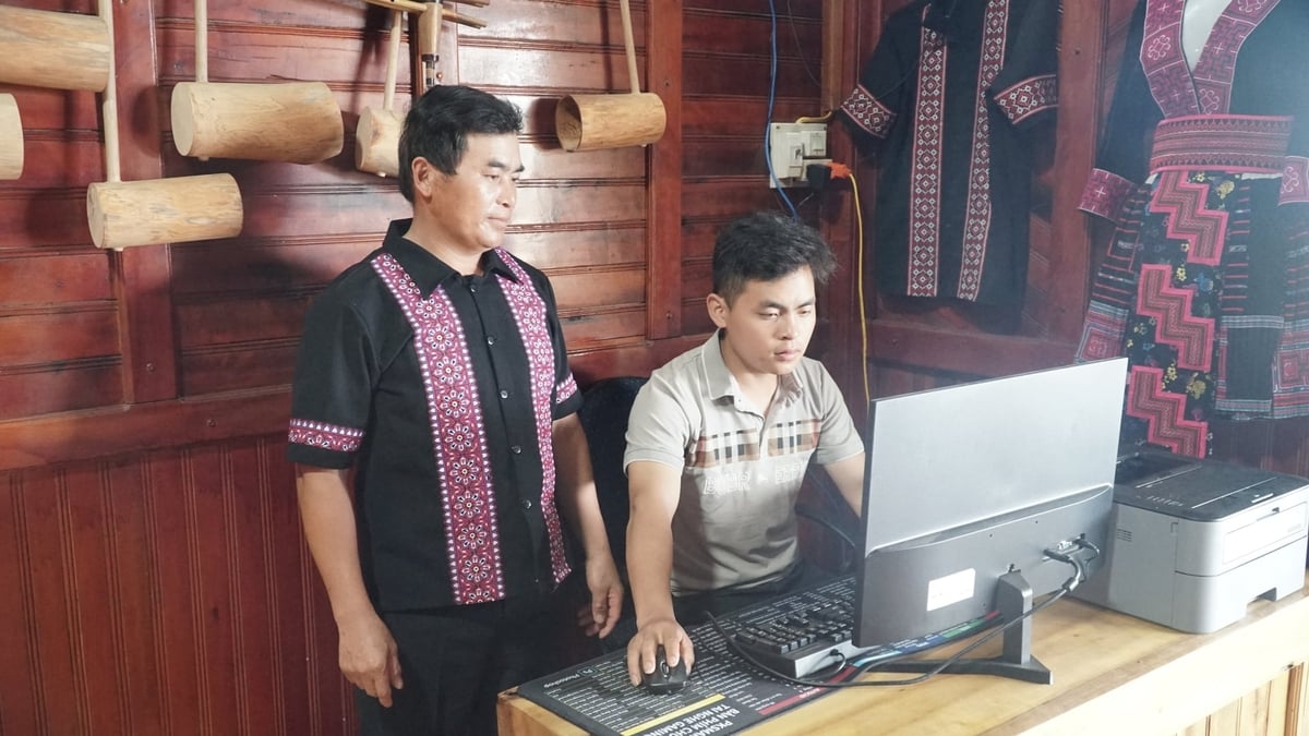 Ông Cừ A Lồng (50 tuổi), chủ homestay A Lồng, đang cùng cậu con trai rà soát danh sách khách đặt phòng. Ảnh: Đức Bình.