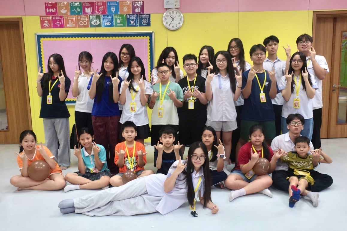 Các anh chị tình nguyện viên chụp hình lưu niệm cùng các em nhỏ. Ảnh: CLB.