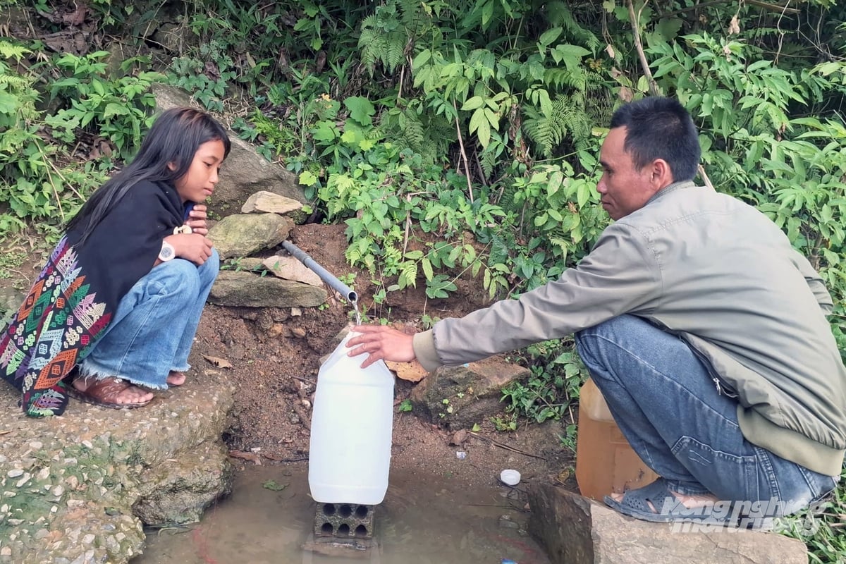 Người dân phải ra cạnh tỉnh lộ 587 để xách từng can nước về dùng. Ảnh: Võ Dũng.