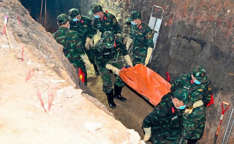 Cẩn thận đưa hài cốt liệt sĩ ra bên ngoài. Ảnh: Hồng Thủy.
