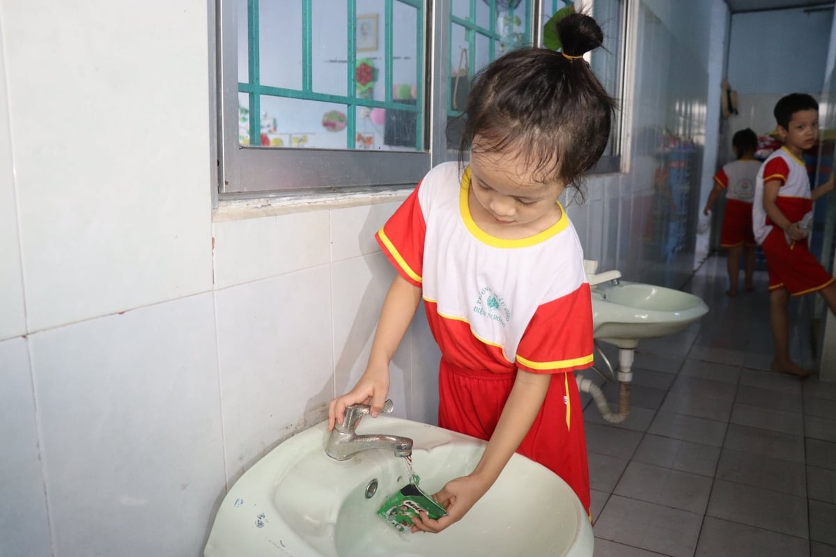 Học sinh trường Mẫu giáo Điện Nam Đông làm sạch vỏ hộp sữa trước khi chuyển đến các điểm thu gom, tái chế. Ảnh: Lan Anh.