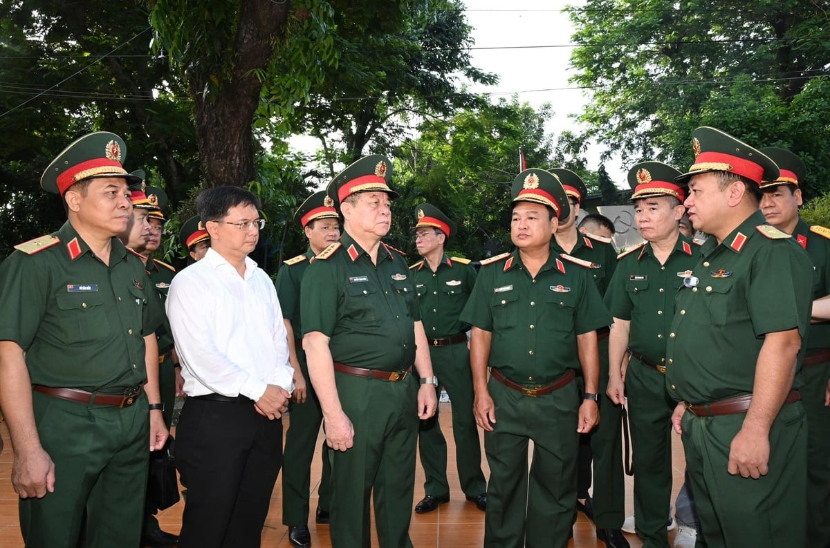 Đại tướng Nguyễn Trọng Nghĩa nghe Thiếu tướng Nguyễn Thành Trung, Chính ủy Bộ Tư lệnh TP.HCM báo cáo kết quả tìm kiếm hài cốt liệt sĩ. Ảnh: Hồng Thủy.