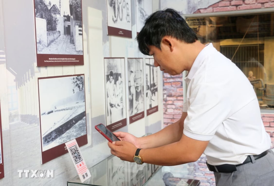 Du khách quét QR để tìm hiểu thông tin tại Nhà trưng bày thân thế, sự nghiệp Chủ tịch Tôn Đức Thắng, nằm trong Khu lưu niệm Chủ tịch Tôn Đức Thắng, thuộc xã Mỹ Hòa Hưng, tỉnh An Giang. Ảnh: Công Mạo/TTXVN.