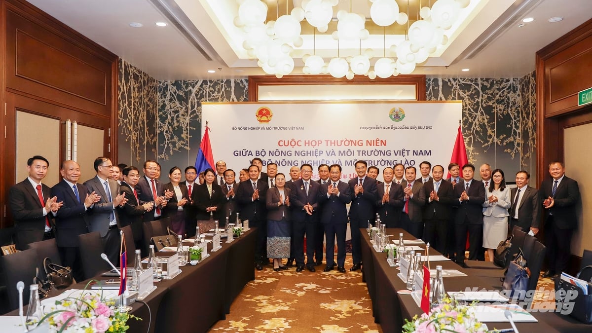 Bộ trưởng Trịnh Việt Hùng và Bộ trưởng Linkham Douangsavanh chụp ảnh lưu niệm với đoàn công tác. Ảnh: Khương Trung.
