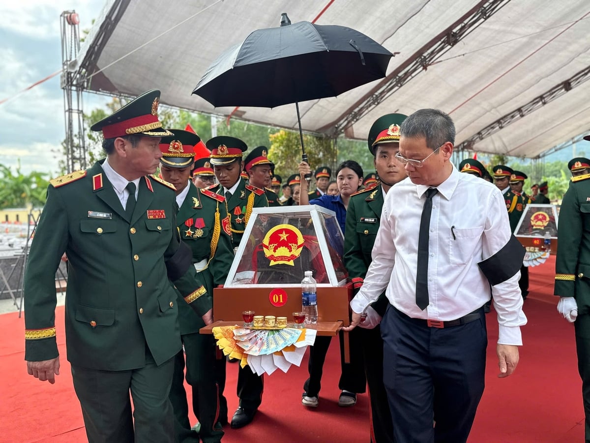 Trung tướng Lê Ngọc Hải, Tư lệnh Quân khu 5 (bìa trái), cùng ông Nguyễn Mạnh Hùng, Chủ tịch UBND TP. Đà Nẵng (áo trắng), theo đoàn đưa hài cốt các liệt sĩ đến nơi an táng. Ảnh: Lan Anh.