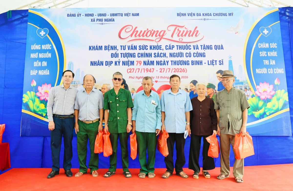 Các đồng chí lãnh đạo xã thăm hỏi, trao quà động viên các đối tượng chính sách sau khi hoàn thành khám sức khỏe. Ảnh: Hoài Lưu.