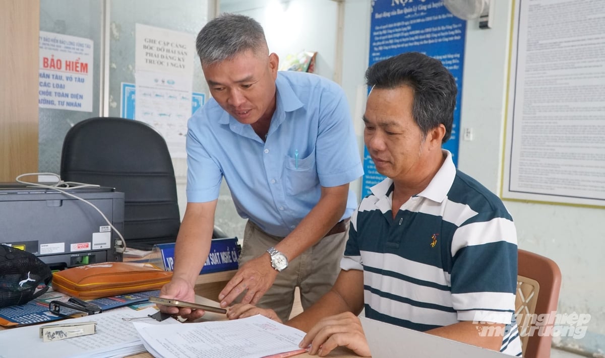 Cán bộ Văn phòng kiểm soát nghề cá đang hỗ trợ ngư dân cập nhật, đối soát dữ liệu tàu cá trên hệ thống số, từng bước thay thế phương thức quản lý thủ công bằng cơ sở dữ liệu nghề cá quốc gia. Ảnh: Lê Bình.