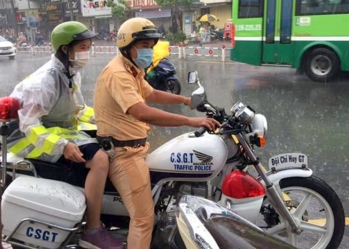 chuong-trinh-tiep-suc-ky-thi-co-mot-khong-hai-120722_20200810_169.jpg Một chiến sĩ CSGT hỗ trợ thí sinh nhanh chóng đến điểm thi Trường THPT Ernst Thalmann (quận 1, TPHCM) giữa cơn mưa tầm tã. Ảnh: Đức Mừng.