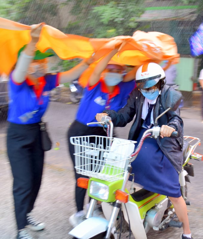 chuong-trinh-tiep-suc-ky-thi-co-mot-khong-hai-121331_20200810_496.jpg Các thanh niên tình nguyện dầm mình dưới cơn mưa lớn để che mưa cho các thí sinh khi vừa tới điểm dự thi. Ảnh: Trần Trung.
