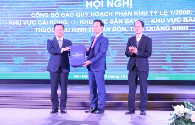 Ông Cao Tường Huy, Phó Chủ tịch Thường trực UBND tỉnh Quảng Ninh trao hồ sơ 3 quy hoạch phân khu KKT Vân Đồn cho đại diện Ban Quản lý KKT Vân Đồn. Ảnh: Cường Vũ