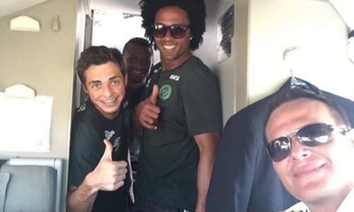Các cầu thủ đội bóng đá Chapecoense chụp ảnh với phi công Quiroga trên chuyến bay định mệnh. Ảnh: Mirror.