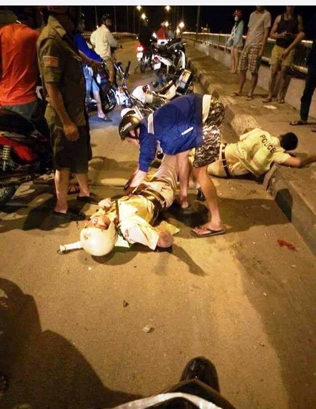 Hình ảnh 2 chiến sĩ CSGT bị thương nằm bất động trên cầu, được lan truyền trên mạng.