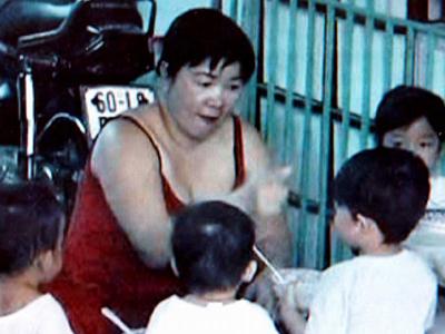 Bà Hoa đang bặm môi trợn mắt quát và đút cho một bé ăn (ảnh do đài truyền hình Đồng Nai cung cấp)