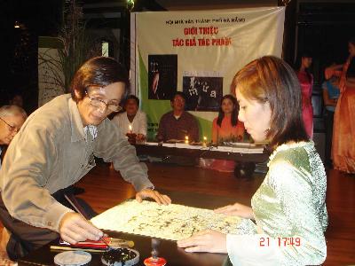 Anh Khanh viết thư pháp trên áo dài để bán gây quỹ giúp các sinh viên nghèo vượt khó.
