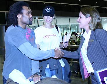 Karembeu cùng vợ siêu mẫu Adriana (đội mũ) tại sân bay Tân Sơn Nhất, tối 7/4