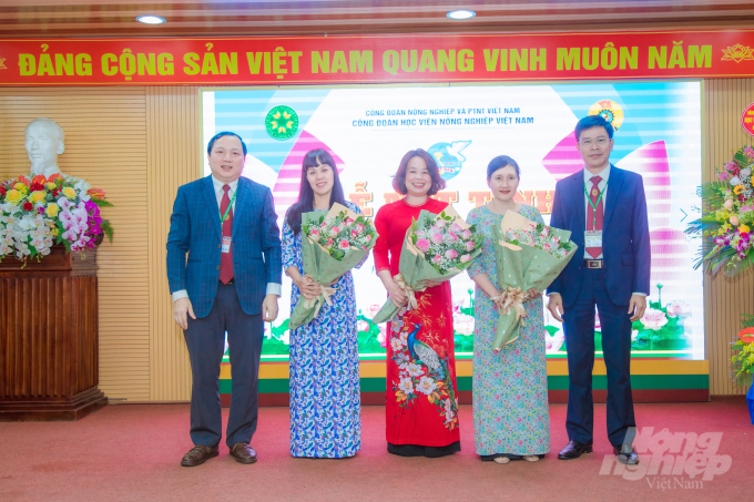 Ông Vũ Ngọc Huyên, Phó Giám đốc Học viện và ông Nguyễn Tất Thắng, Chủ tịch Công đoàn Học viện gửi tặng những bó hoa tươi thắm tới đại diện khách mời và cán bộ, viên chức nữ trong Học viện. Ảnh: HG.
