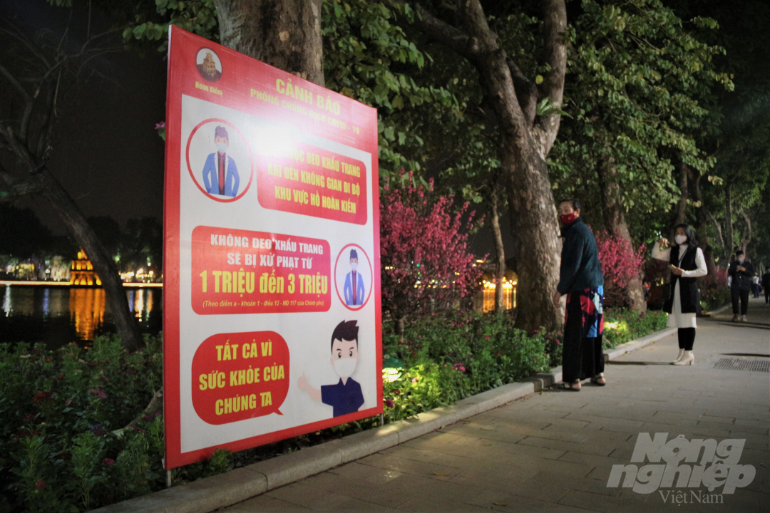Biển cảnh báo được dựng quanh khu vực hồ nhắc nhở người dân du xuân đón tết nhưng vẫn phải chú ý công tác phòng chống dịch bệnh Covid-19.
