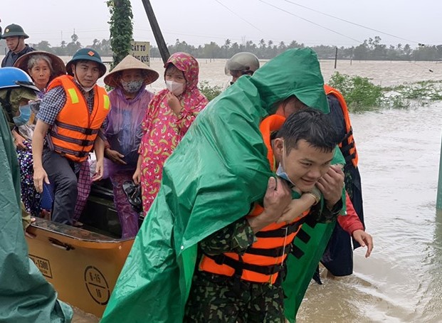 Các chiến sĩ Biên phòng Bình Định di dời người dân ra khỏi khu vực bị lũ cô lập. Ảnh: VGP.