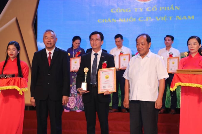 Thứ trưởng Bộ NN-PTNT Phùng Đức Tiến (bên trái) và Chủ tịch Tổng hội Nông nghiệp và PTNT Việt Nam Hồ Xuân Hùng (bên phải) vinh danh Thương hiệu Vàng nông nghiệp năm 2020 Công ty Cổ phần Chăn nuôi C.P Việt Nam. Ảnh: Phương Phương.