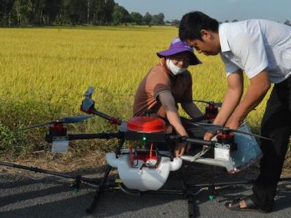 An engineer from HIRA instructs a farmer to use HLD-18 drone. Photo VAN