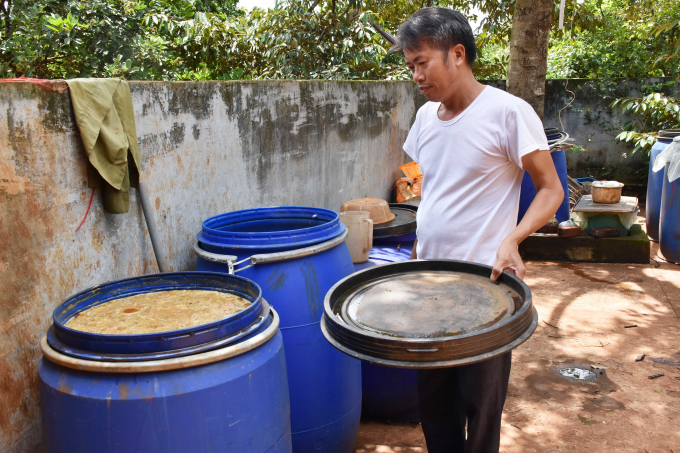 Anh Thiện bên thùng phuy chứa chế phẩm IMO. Ảnh: Lê Khánh.