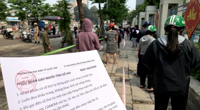 Mỗi người đến nhận gạo được phát một 'Phiếu nhận gạo nghĩa tình' có ghi đầy dủ hướng dẫn về phòng dịch cũng như quy định 1 người 1 tuần được nhận 3kg gạo. Ảnh: Trần Anh.