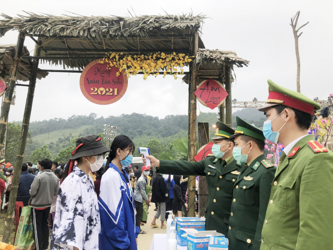 Kiểm tra thân nhiệt cho bà con trước khi vào chợ. Ảnh: Đ.Trí