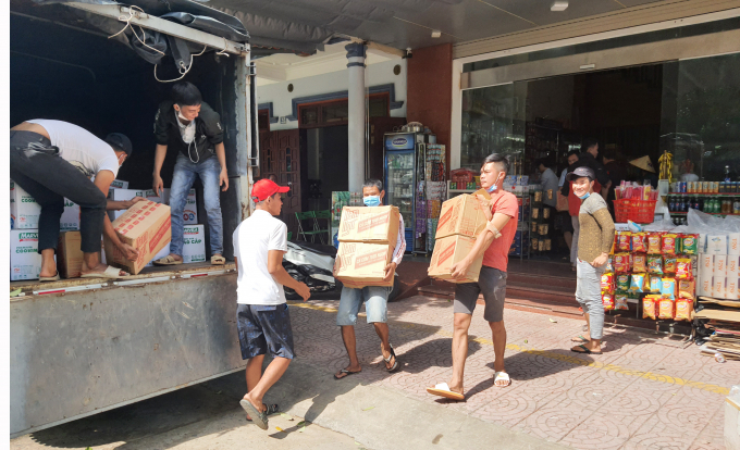 Hỗ trợ thôn cấp phát hàng cứu trợ cho bà con vùng lũ. Ảnh: N.Tâm