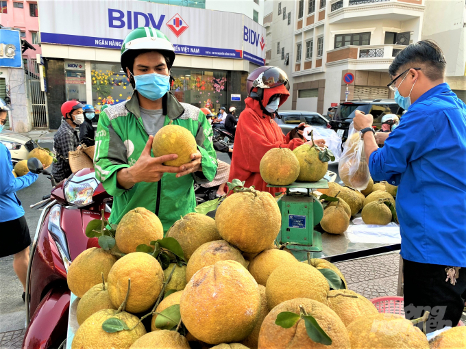g-142618_14.jpg Nhiều người đi ngang điểm bán bưởi 'giải cứu' ghé mua ủng hộ. Ảnh: MS.