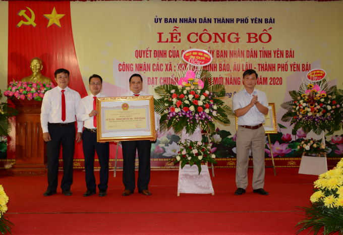 a1-150912_78.jpg Ông Nguyễn Đức Điển (phải) - PGĐ Sở NN-PTNT tỉnh Yên Bái trao bằng công nhận và tặng lẵng hoa của tỉnh Yên Bái cho các xã đạt chuẩn NTM nâng cao. Ảnh: Thái Sinh.
