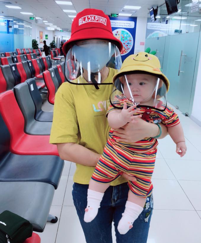 Các cháu bé được gia đình trang bị dụng cụ bảo hộ an toàn khi đi chích ngừa phòng chống dịch. Ảnh: MV.