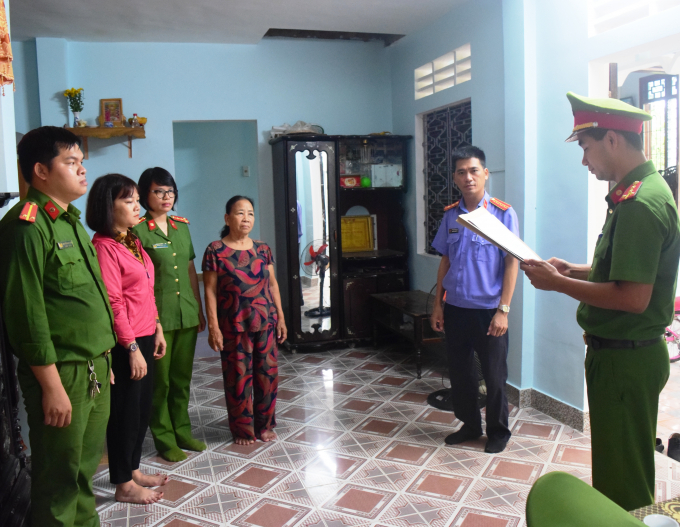anh-165310_843.jpg Lực lượng chức năng đang tiến hành lệnh khởi tố đối với bà Trần Thị Thu (áo khoác hồng). Ảnh: C.Q.