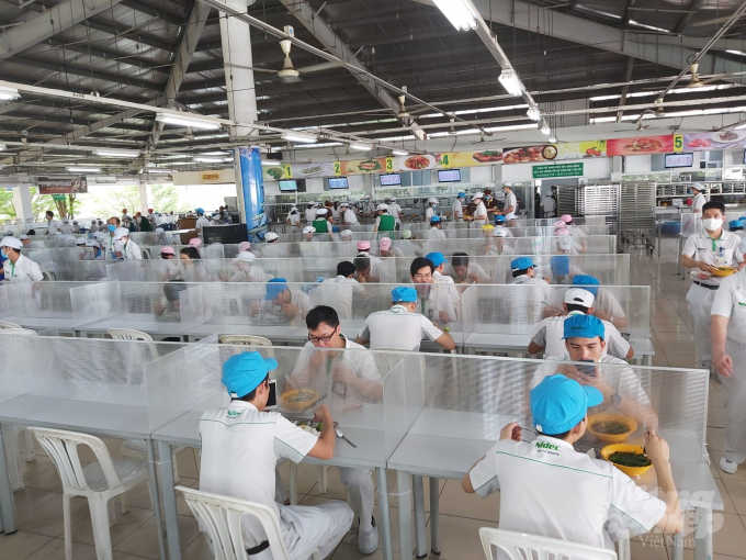 Công nhân Công ty Nissan ăn trưa tại căn tin có kính ngăn chống lây nhiễm dịch bệnh. Ảnh: H.T.