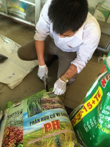 Lấy mẫu phân bón đi phân tích. Ảnh: Đức Trung.