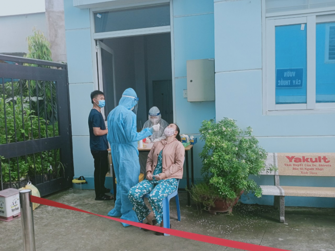 Cán bộ y tế vất vả phục vụ người dân đến làm xét nghiệm.