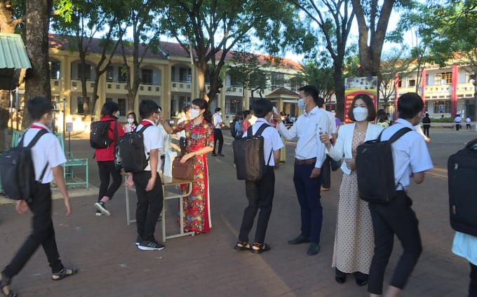 Giáo viên tổ chức đo thân nhiệt và các biện pháp phòng chống Covid-19 trước khi cho học sinh vào lớp. Ảnh: Tất Thành.