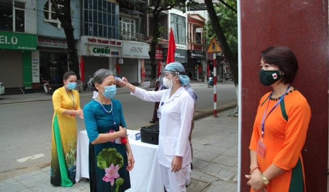 Công tác kiểm tra thân nhiệt cử tri trước khi tiến hành bỏ phiếu bầu. Ảnh: Cổng TTĐT Vĩnh Phúc.