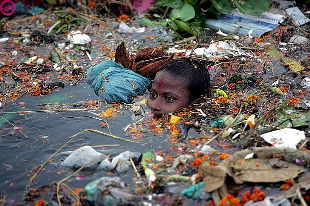 Một cậu bé đang khó khăn bơi qua con sông Yamuna - nơi mà người dân thường xuyên vứt rác thải xuống
