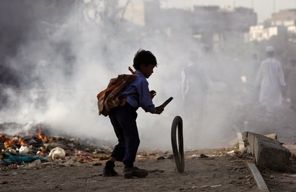 Rác trở thành đồ chơi cho cậu bé này. Hình ảnh được chụp ở Karachi, Pakistan.