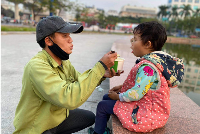 Anh Hùng mua sẵn cháo mang theo cho con mỗi sáng đi bán hàng.