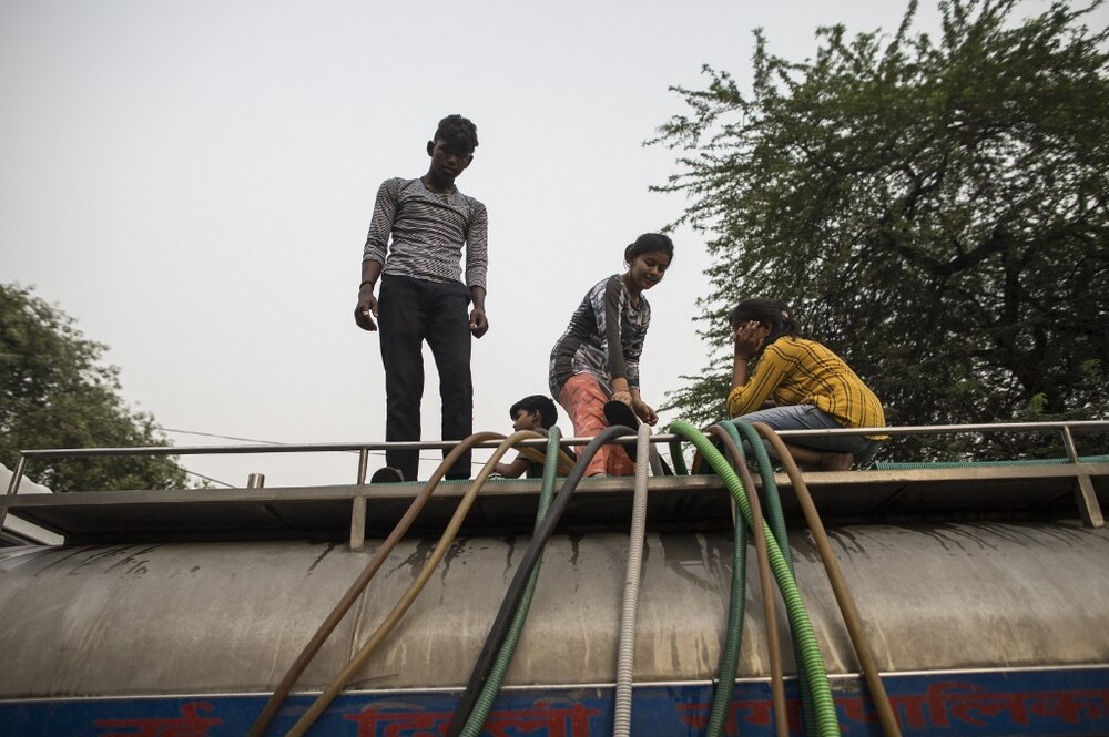 Người dân ròng dây dẫn nước ngọt từ xe téc tới một khu dân cư ở New Delhi hôm 3/5. Friederike Otto, nhà khoa học khí hậu tại Đại học Hoàng gia London, cho hay biến đổi khí hậu khiến nắng nóng xảy ra thường xuyên hơn với nền nhiệt cao hơn. Các đợt nắng nóng sẽ tấn công Ấn Độ khoảng 4 năm một lần thay vì 50 năm một lần như trước đây.