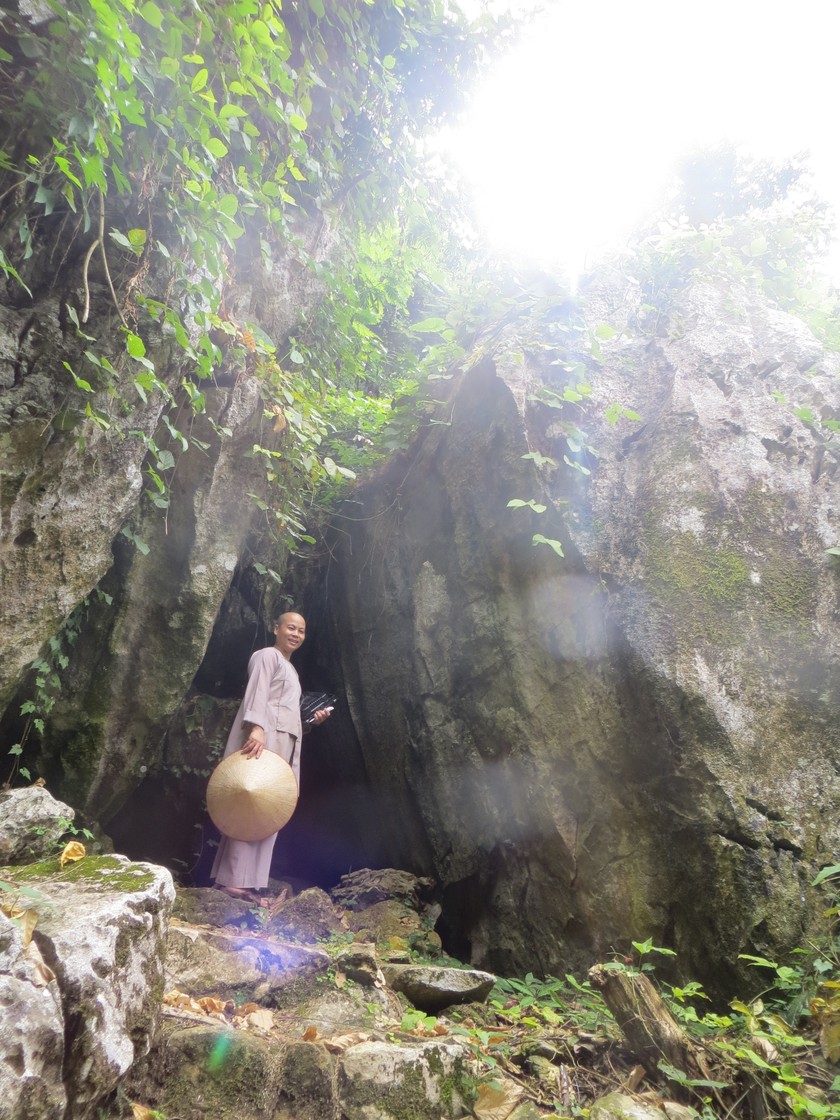 Sư cô Thích Nữ Diệu Hiếu bên cửa hang núi dẫn vào chùa São.