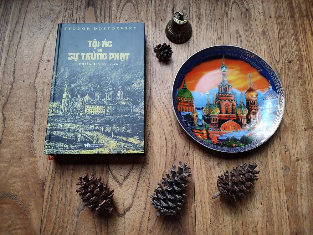 Ảnh chụp cuốn 'Tội ác và sự trừng phạt' bản tiếng Việt độc giả gửi tặng Thiên Lương bên cạnh chiếc đĩa lưu niệm về thành phố Saint Petersburg. Ảnh: NVCC.