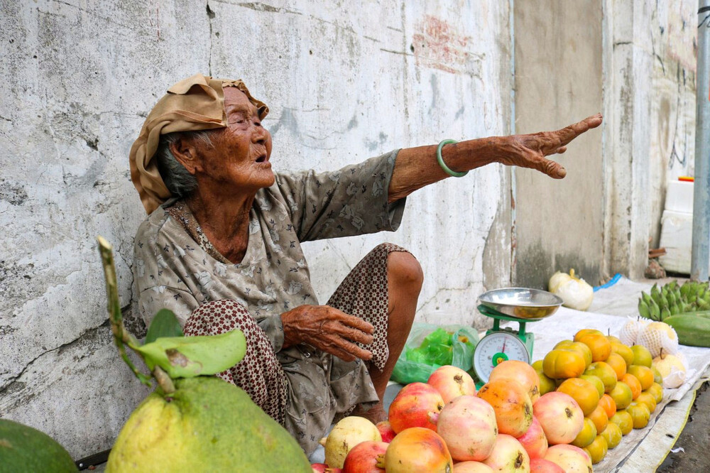 Hình ảnh bà cụ luôn tay, luôn miệng mời chào mua trái cây đã trở thành quen thuộc với người dân địa phương (Ảnh: Nguyễn Vy).