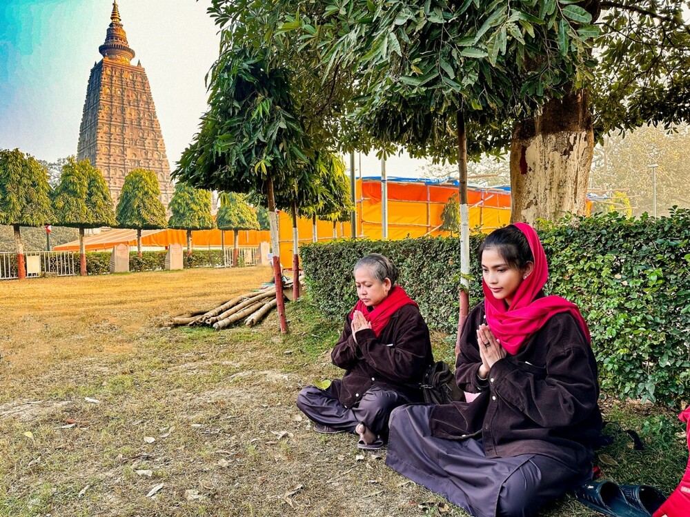 Mẹ con người đẹp ngồi nghỉ ngơi, cầu nguyện dưới tán cây xanh trong Bồ Đề Đạo Trang.