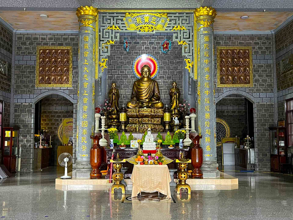 Chánh điện chùa thờ Đức Phật Thích Ca Mâu Ni và các tượng Phật, Bồ tát. Ngoài màu xám của đá, chùa còn có điểm nhấn là màu vàng đồng từ các bức tượng và hoa văn, chữ viết chạm nổi trên cột. Ảnh: Ý Mỹ