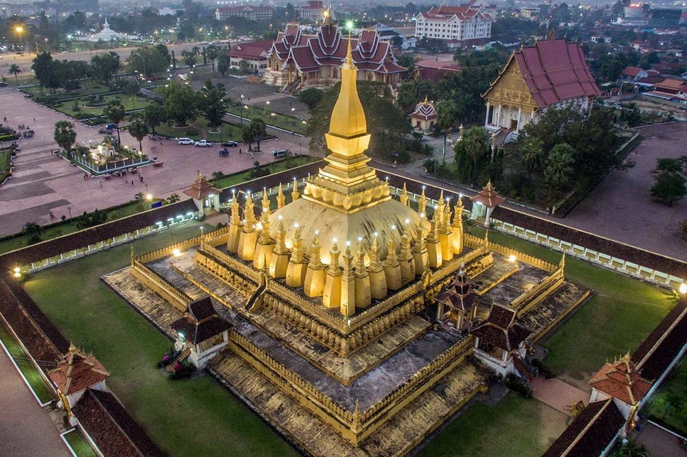 Vế kiến trúc, trung tâm Thạt Luổng là một tòa tháp cao 45 mét, được dát vàng rực rỡ. Đế của khối tháp là một đài sen hình vuông đang nở tung những cánh vàng ra bốn phía. Ảnh: Cox & Kings.